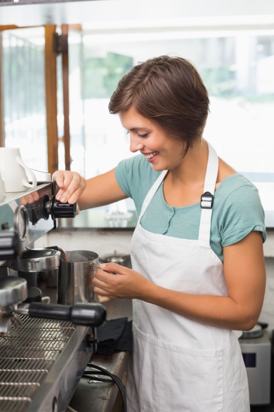 Bella cameriera in posa accanto alla macchina da caffè - Stockphoto  #17435444